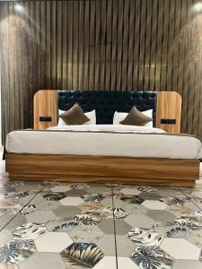 a bedroom with a bed with a wooden frame at Troy Resorts and wellness in Zirakpur
