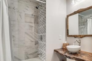 a bathroom with a tub and a sink and a mirror at Game Room and Backyard Modern Altoona Home! in Altoona +19 photos