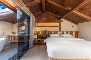 香格里拉香格里拉言意客栈的一间带白色床的卧室和一间浴室