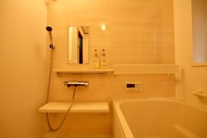 a bathroom with a tub and a toilet and a sink at THE KOYA Nagano in Nagano +47 photos
