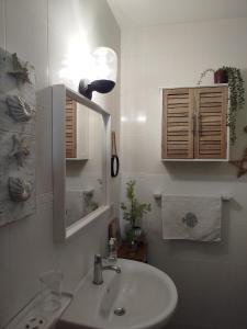 a bathroom with a sink and a light and a mirror at Casa Sebadal in La Santa