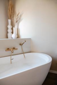 Una bañera blanca con grifo en un baño. en Jávea Boutique Stays - Holiday Apartments, en Jávea