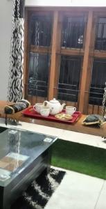 a table with a tray of dishes on a window at Thistle Cosy Villa in Kozhikode