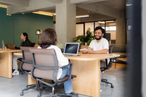 a group of people sitting at a table with a laptop at Outsite Mexico City Roma Sur - Work, Connect, Explore in Mexico City