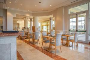 Un restaurante con mesas y sillas y un bar. en Lucania Palazzo Hotel, en Comodoro Rivadavia