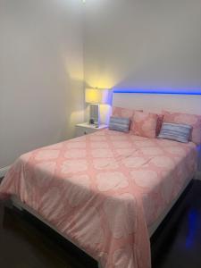 ein Schlafzimmer mit einem rosa Bett mit einer rosa Bettdecke in der Unterkunft Cozy, Modern, Family Fun Home near AT&T Stadium, Rangers, Six Flags, Epic Water Park in Arlington