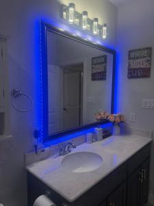 ein Badezimmer mit einem Waschbecken und einem Spiegel mit blauen Lichtern in der Unterkunft Cozy, Modern, Family Fun Home near AT&T Stadium, Rangers, Six Flags, Epic Water Park in Arlington + 54 Fotos