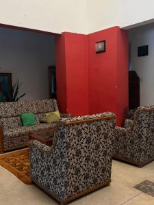Peace Haven في بانادورا: غرفة معيشة بها كنبتين وجدار احمر