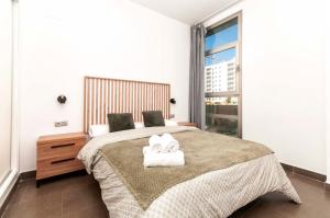 ein Schlafzimmer mit einem großen Bett und zwei Handtüchern in der Unterkunft Palm Suites Gran Vía in Alicante + 43 Fotos