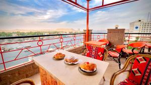 a balcony with a table with two dishes of food on it at Nile Hotel in Aswan