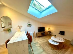 a living room with a skylight and a table and chairs at Charmant deux pièces en plein centre-ville de NARBONNE in Narbonne