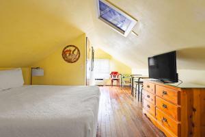 une chambre avec un lit et une télévision sur une commode dans l'établissement Curry House - Room 9, à Key West