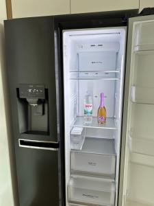 a refrigerator with its door open with drinks and a bottle at FUX LUXURY rooftop terrace JACUZZI & BBQ in Zadar