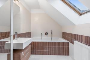 een badkamer met 2 wastafels en een bad bij The Dante House Šeberov in Praag +41 foto's