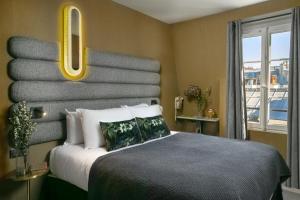 a bedroom with a large bed with a window at La Planque Hotel in Paris