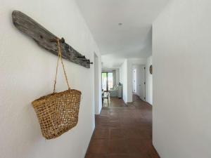 Casapueblo Rent Cachagua CP 18 في Cachagua: ممر مع حقيبة خوص معلقة على الحائط +30 صورة