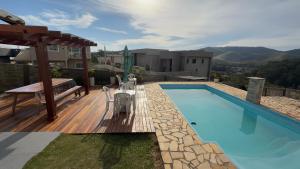 a swimming pool on a deck next to a house at Suite Requinte da Serra in Miguel Pereira