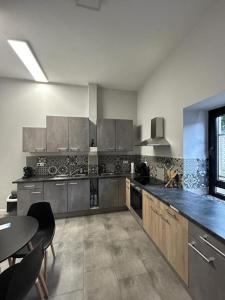 a large kitchen with a table and a counter at Sia Apartments Hotel in Essen