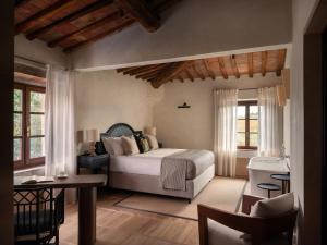 a bedroom with a bed and a table and chairs at Fattoria di Vegi in Castellina in Chianti