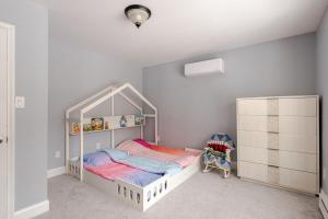 a bedroom with a white bed and a crib at Lakeview Family Retreat Newly Renovated 4BR House in Pocono Country Place +47 photos