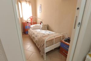 a small bedroom with a bed and a window at U Casteddu Home Motta Sant'Anastasia 1 in Motta SantʼAnastasia