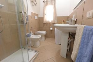 a bathroom with a sink and a toilet and a shower at U Casteddu Home Motta Sant'Anastasia 1 in Motta SantʼAnastasia