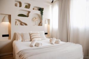 Un dormitorio con una cama blanca con toallas. en Jávea Boutique Stays - Holiday Apartments, en Jávea