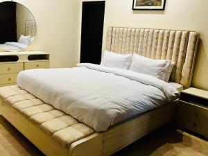 a bedroom with a large bed and a mirror at OSMA Residency in Islamabad +8 photos