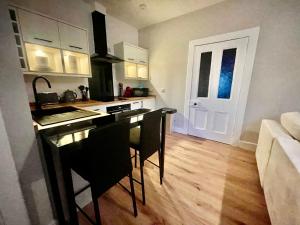 a kitchen with a table and chairs in a room at The Nairn Neuk - Couples Cosy Getaway in Nairn