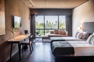a hotel room with two beds and a desk at KOS Pilar Hotel in Pilar