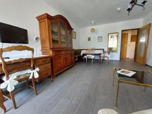 een slaapkamer met een houten ladekast en een eetkamer bij Antoinette Kurappartement in Bad Krozingen