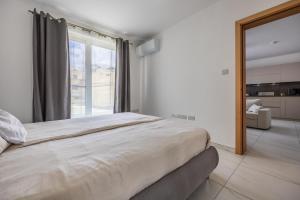Wild Thyme - By Solea Holiday Homes في San Ġwann: غرفة نوم بسرير كبير ونافذة كبيرة