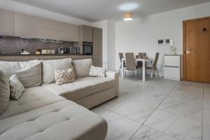 a living room with a couch and a kitchen at Wild Thyme - By Solea Holiday Homes in San Ġwann