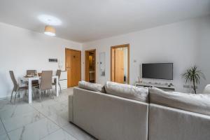 Wild Thyme - By Solea Holiday Homes في San Ġwann: غرفة معيشة بها أريكة وطاولة