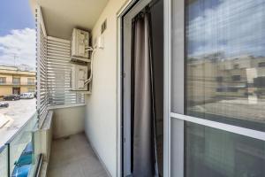 Wild Thyme - By Solea Holiday Homes في San Ġwann: بلكونه مع نافذه واطلاله على شارع