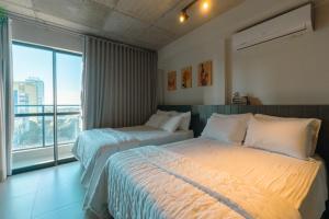 马林加Excelente Espaço Centro CA904的有两张床和一扇大窗户的酒店房间