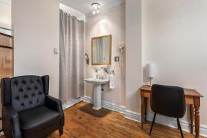 a bathroom with a chair and a sink at Hotel Charles-Alexandre - Par Aneyro in Quebec City +108 photos