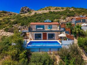 a house with a swimming pool in front of a hill at Villa Elvin in İslâmlar