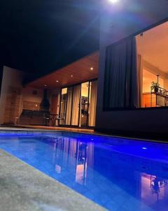 Loft Cerrado de Minas في جوبوتيكاتوباس: مسبح في بيت فيه اضاءة زرقاء