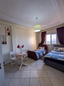 a bedroom with two beds and a table with flowers at artisanat in Mohammedia