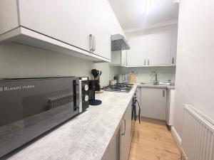 Una cocina con gabinetes blancos y encimera. en The Clifton Meridian - Boutique Luxury in Bristol, en Bristol 5 fotos más