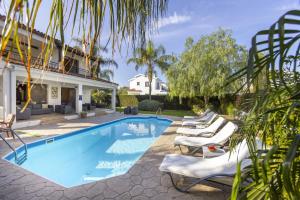 een zwembad met ligstoelen naast een huis bij Relax Villa in Lachi
