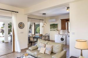 een woonkamer en keuken met een bank en een tafel bij Relax Villa in Lachi