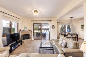 een woonkamer met een bank en een tv bij Relax Villa in Lachi