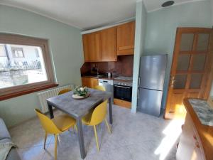 a kitchen with a table and chairs and a refrigerator at Bella Vista casa vacanze in Grosio