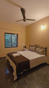 a bedroom with a large bed with a ceiling fan at Halfway Home Hilltop in Gokarna