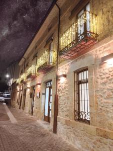 a building with windows and balconies on a street at night at Apartamentos LA CAÑADA DE OSMA in El Burgo de Osma