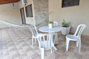einen weißen Tisch und Stühle in einem Zimmer mit Fußboden in der Unterkunft Casa Familiar Morada in Aparecida