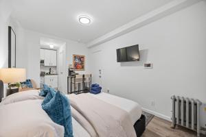 a bedroom with two beds and a tv on the wall at Highly Recommended Studio Near Times Square in New York