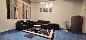 Una sala de estar con un sofá y un refrigerador. en Minny house Home stay, en Ban Komo Sip Paet